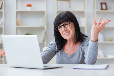 Bilgisayarla mücadele eden yaşlı kadın.