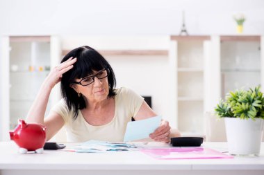 Faturalarını ödemeye çalışan olgun bir kadın.