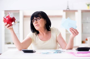 Faturalarını ödemeye çalışan olgun bir kadın.