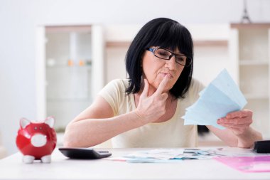 Faturalarını ödemeye çalışan olgun bir kadın.