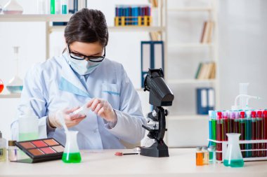 Laboratuar kimyageri güzellik ve makyaj ürünlerini kontrol ediyor.
