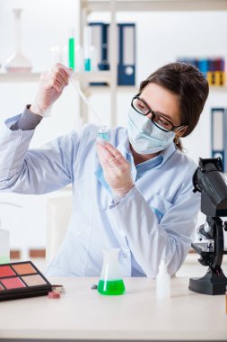 Laboratuar kimyageri güzellik ve makyaj ürünlerini kontrol ediyor.
