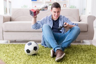 Genç adam evde bilgisayar oyunu oynuyor.