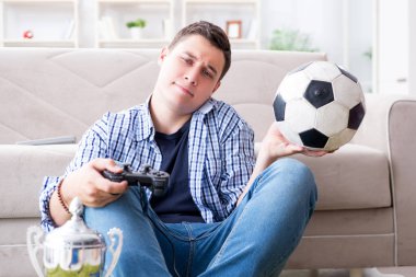 Genç adam evde bilgisayar oyunu oynuyor.