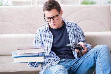 Çalışmayı ve oyun oynamayı dengelemeye çalışan genç öğrenci