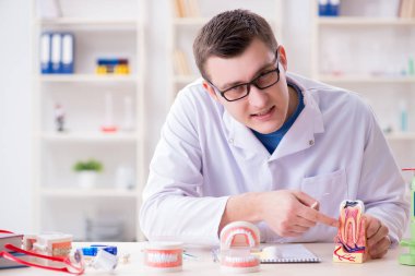 Tıp laboratuarına diş implantı yerleştiren dişçi.