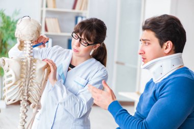 Doktor boynu yaralanan hastaya durumu açıklıyor.
