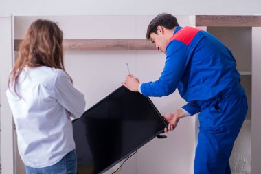 TV tamircisi evde televizyon tamir ediyor.