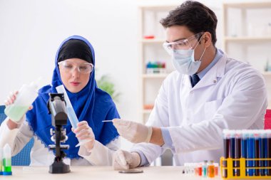 Laboratuvarda çalışan iki kimyager.