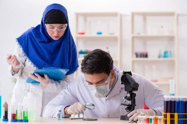 Laboratuvarda çalışan iki kimyager.