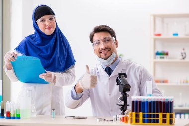 Laboratuvarda çalışan iki kimyager.