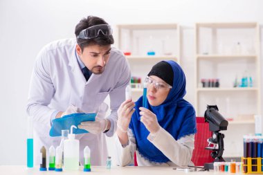 Laboratuvarda çalışan iki kimyager.