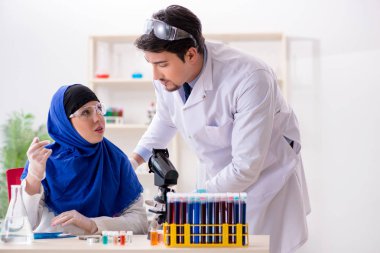 Laboratuvarda çalışan iki kimyager.