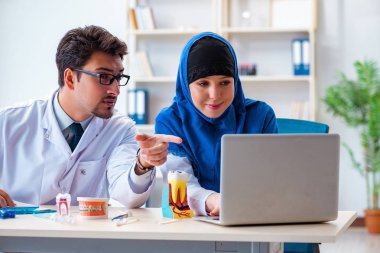 Diş hekimi ve asistanı yeni diş implantı üzerinde çalışıyor.