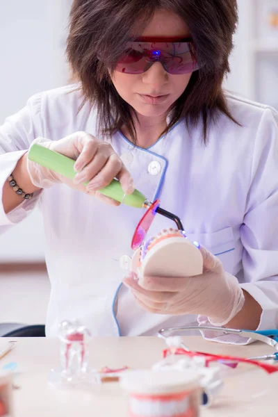 Женщина-дантист работает над имплантатом зубов — стоковое фото
