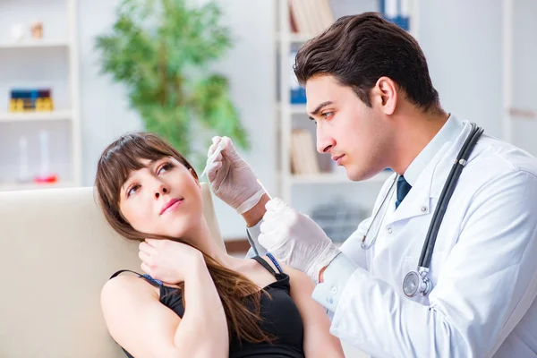 Médico revisando el oído de los pacientes durante el examen médico —  Fotos de Stock