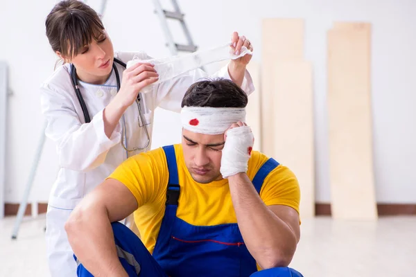 Pracownik z ranną głową i lekarzem — Zdjęcie stockowe