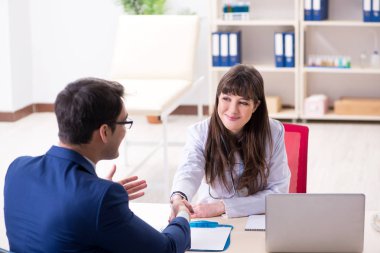 İş adamı doktorla sağlık sorunlarını tartışıyor