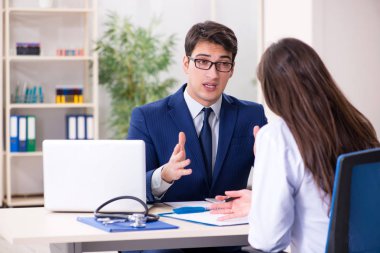 İş adamı doktorla sağlık sorunlarını tartışıyor