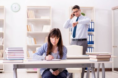 Erkek öğretim görevlisi bayan öğrenciye ders veriyor.