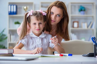 Anne, kızına ödevlerinde yardım ediyor.