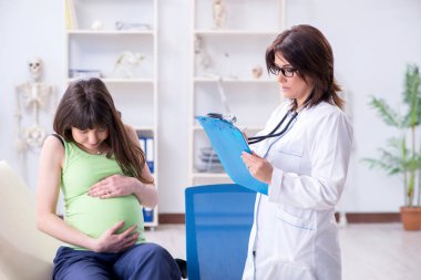 Hamile kadın düzenli kontrol için doktoru ziyaret ediyor.