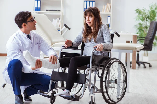 Mężczyzna lekarz badający pacjentkę na wózku inwalidzkim — Zdjęcie stockowe
