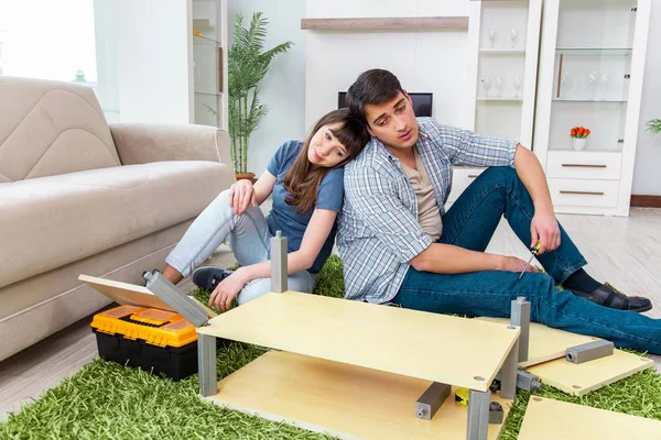 Yeni evde mobilya montajı yapan genç bir aile. — Stok fotoğraf
