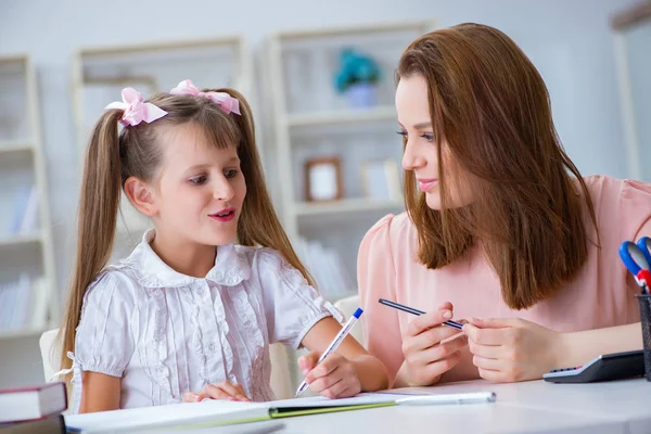 Mãe ajudando sua filha a fazer lição de casa — Fotografia de Stock