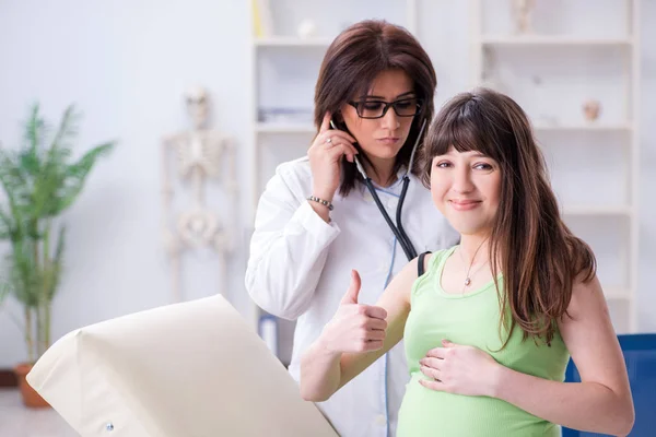 Mujer embarazada que visita al médico para chequeo regular —  Fotos de Stock