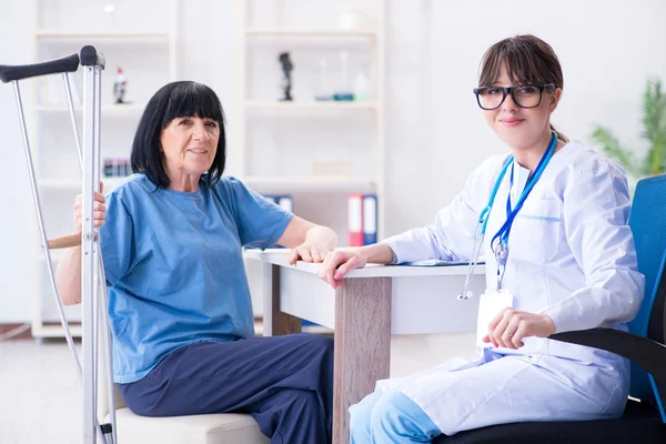 Dokter onderzoeken van oude volwassen vrouw na incident — Stockfoto