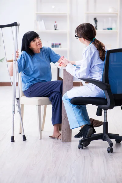 Dokter onderzoeken van oude volwassen vrouw na incident — Stockfoto