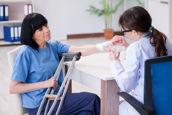 Dokter onderzoeken van oude volwassen vrouw na incident — Stockfoto