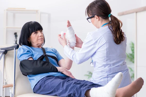 Doktor olaydan sonra yaşlı kadını muayene ediyor. — Stok fotoğraf