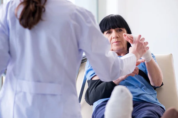 Doktor olaydan sonra yaşlı kadını muayene ediyor. — Stok fotoğraf