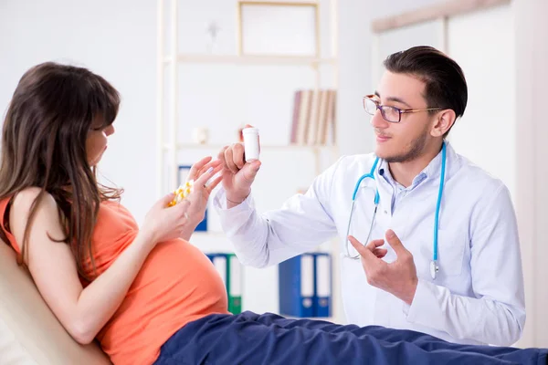 Těhotná žena se svým manželem navštívit lékaře na klinice — Stock fotografie