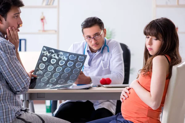 Mulher grávida com o marido visitando o médico na clínica — Fotografia de Stock