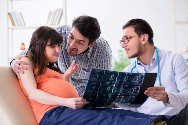 Gravid kvinna med make besöker läkare på kliniken — Stockfoto