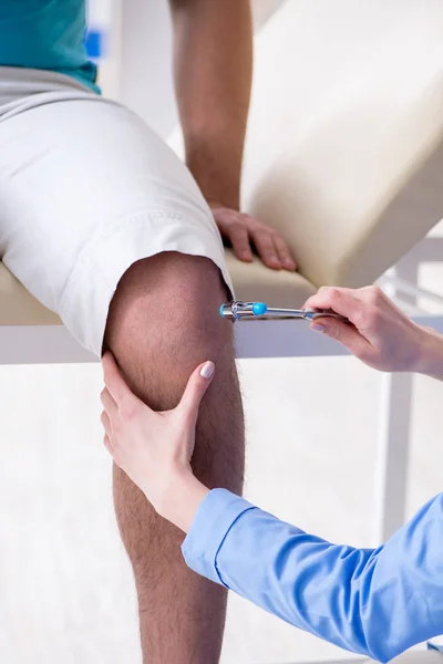 Médico verificando reflexos nervosos com martelo — Fotografia de Stock