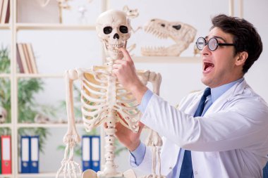 Çılgın profesör insan iskeleti üzerinde çalışıyor.