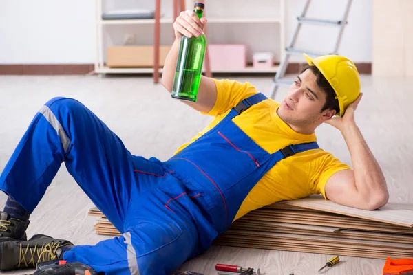 Reparador de piso bebiendo alcohol durante el descanso —  Fotos de Stock