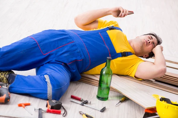 Fußbodenreparateur trinkt in der Pause Alkohol — Stockfoto