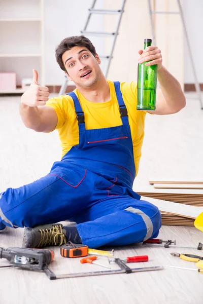 Fußbodenreparateur trinkt in der Pause Alkohol — Stockfoto