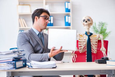 İskeletle çalışan bir iş adamı.