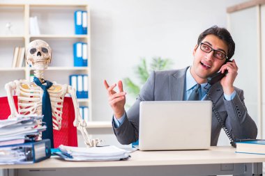 İskeletle çalışan bir iş adamı.