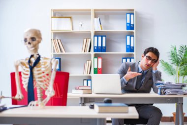 İskeletle çalışan bir iş adamı.