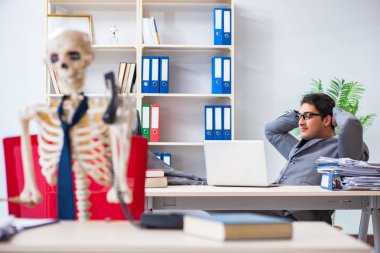 İskeletle çalışan bir iş adamı.