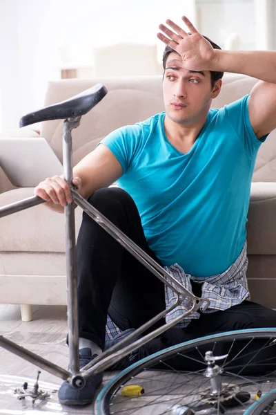 Młodzieniec naprawiający rower w domu — Zdjęcie stockowe