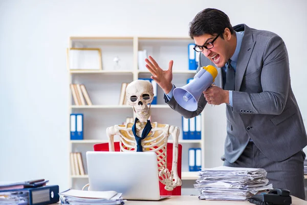 Kızgın patron iskelet çalışanına bağırıyor.