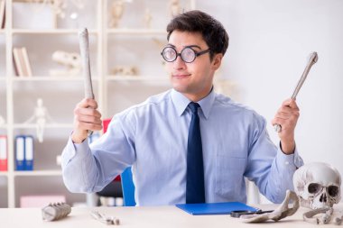 Komik çılgın profesör insan iskeletini inceliyor.